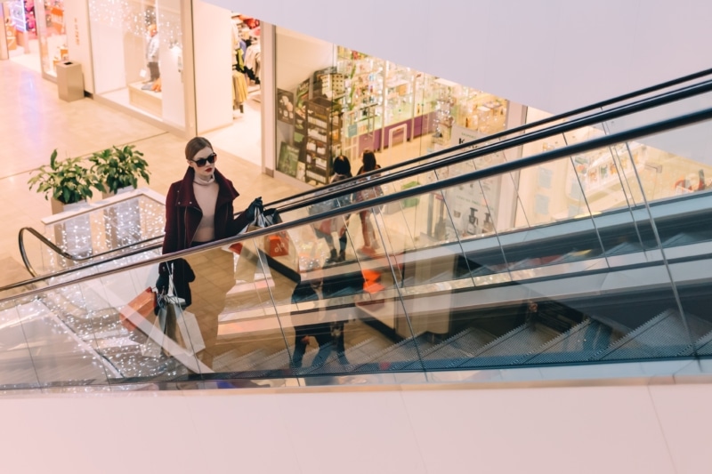 Une femme empruntant un escalator dans un centre commercial